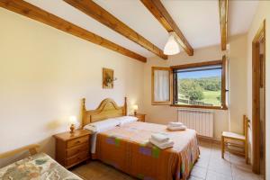 a bedroom with two beds and a window at Les Cases in Sagás +33 photos