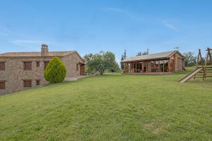 a house with a large yard in front of a building at Les Cases in Sagás