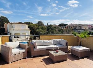 a patio with couches and tables on a balcony at Villa Bahia Azul in Llucmajor