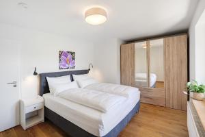 a bedroom with a large bed and a mirror at Ferienwohnung Kalvarienberg in Bad Tölz