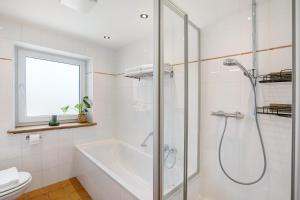 a bathroom with a shower and a tub and a toilet at Ferienwohnung Kalvarienberg in Bad Tölz +27 photos
