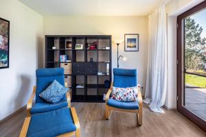 a living room with two chairs and a book shelf at Fewo Kirchheim in Kirchheim