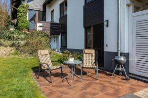 a patio with two chairs and a table and a grill at Fewo Kirchheim in Kirchheim