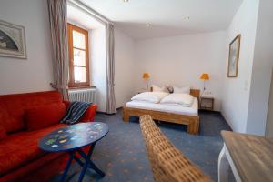 a living room with a bed and a red couch at Klostermeisterhaus in St. Blasien