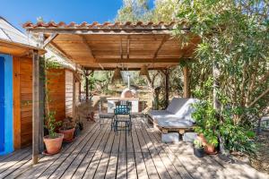 a wooden deck with a pergola with a couch and chairs at Eco Yurta Lanjarón in Lanjarón