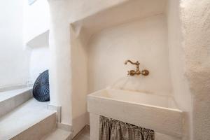 a bathroom with a sink and a faucet on the wall at Suite Cavour 30 in Ostuni