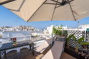 a balcony with a table and chairs and an umbrella at Suite Cavour 30 in Ostuni