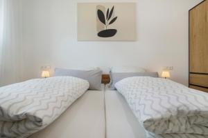 two twin beds in a bedroom with a picture on the wall at Herzensprojekt in Pfullendorf