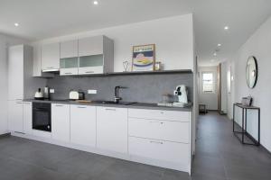 a kitchen with white cabinets and a sink at Herzensprojekt in Pfullendorf