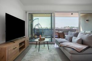 a living room with a couch and a flat screen tv at Herzensprojekt in Pfullendorf
