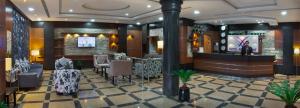 a lobby of a hotel with a bar and chairs at Al Farhan Suites Ishbillia in Riyadh