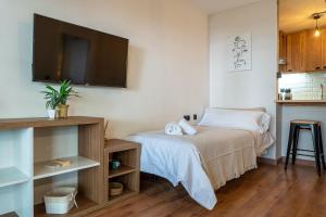 a bedroom with a bed and a flat screen tv at Apartamentos Salou - 111 in Salou +13 photos