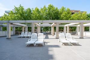 a group of white chairs sitting on a patio at Apartamentos Salou - 111 in Salou