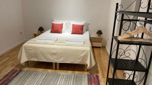 a bedroom with a bed with two red pillows at Retiro Do Tejo in Malpica