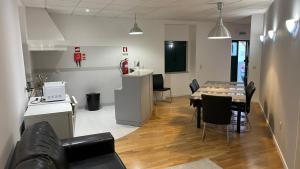 a room with a table and chairs and a kitchen at Retiro Do Tejo in Malpica +3 photos