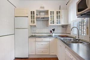 a white kitchen with a sink and a refrigerator at Poniente in Roche