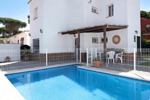 a swimming pool in front of a building with a house at Poniente in Roche