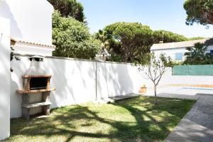 a backyard with a white fence and a pizza oven at Poniente in Roche