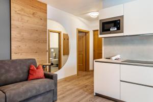 a living room with a couch and a kitchen at Kamerloy Apartments B in Campitello di Fassa