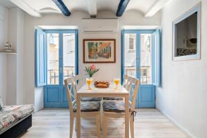 a dining room with blue windows and a table and chairs at Loft Sf5 in L'Ametlla de Mar +12 photos