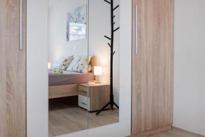 a bedroom with a mirror next to a bed at Casa Karlsplatz in Freiamt