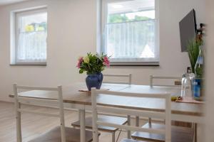 a dining room table with a vase of flowers on it at Casa Karlsplatz in Freiamt