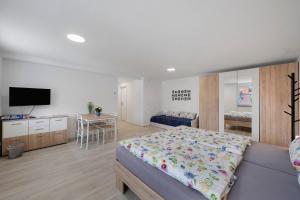 a bedroom with a bed and a table and a television at Casa Karlsplatz in Freiamt