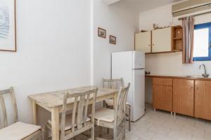 a kitchen with a table and chairs and a refrigerator at Perasma Studios 10 in Kipri +11 photos