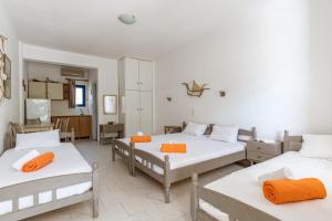 a room with three beds with orange towels on them at Perasma Studios 10 in Kipri