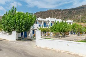 a white house with trees in front of a street at Perasma Studios 10 in Kipri