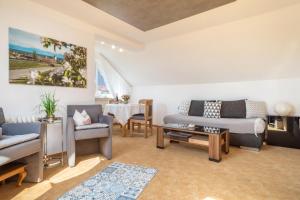 a living room with a couch and chairs and a table at Ferienwohnung Lilo in Immenstaad am Bodensee