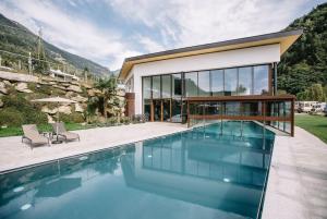 a house with a swimming pool in front of a house at Camping Passeier Löwenzahn in Saltusio