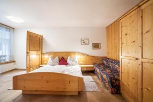 a bedroom with a bed and a couch at Camping Passeier Löwenzahn in Saltusio +14 photos