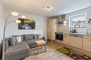 a living room with a couch and a kitchen at Ferienwohnung Alpenblick in Zwiefalten