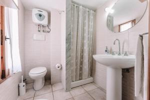a white bathroom with a sink and a toilet at Villa Margherita in Marongiu