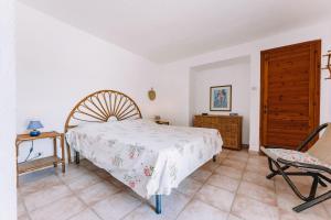 a bedroom with a bed and a chair at Villa Margherita in Marongiu