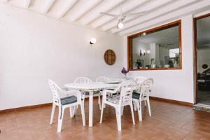 a white dining room with a white table and chairs at Villa Margherita in Marongiu +18 photos
