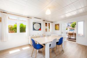 a dining room with a wooden table and blue chairs at Can Juanito in Alcudia