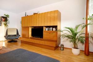 a living room with a large entertainment center with a television at Ferienwohnung Schwenck in Kressbronn am Bodensee