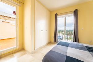 a bedroom with a bed and a large window at Vista Hermosa in Ayamonte