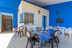 a blue dining room with a table and chairs at Villa Lindarelax in Santa Maria del Focallo