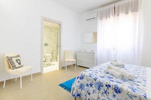 a white bedroom with a bed and a bathroom at Villa Lindarelax in Santa Maria del Focallo +18 photos