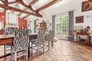 a dining room with a wooden table and chairs at Bastide Lou Pèbre D’aï in La Roquebrussanne