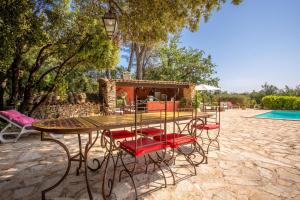 a table and chairs sitting next to a pool at Bastide Lou Pèbre D’aï in La Roquebrussanne