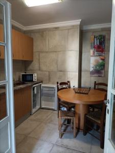 a kitchen with a table and chairs and a microwave at Akademia House - Santarém in Santarém