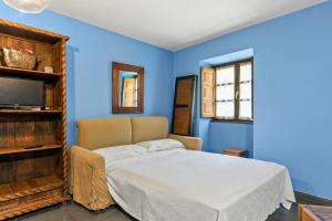 a blue bedroom with a bed and a tv at Puente del Narcea 2 in Cibuyo