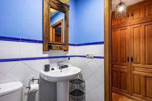 a bathroom with a sink and a toilet and a mirror at Puente del Narcea 2 in Cibuyo +23 photos