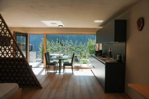 a kitchen and dining room with a table and chairs at Aktiv Lodge Meran - Garden One in San Martino