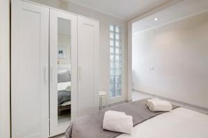 a white bedroom with a bed and a mirror at Bay View Albufeira in Albufeira +37 photos