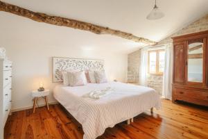 a bedroom with a white bed with a wooden floor at La Belle Parenthèse à la Rochelle in Vergné +29 photos